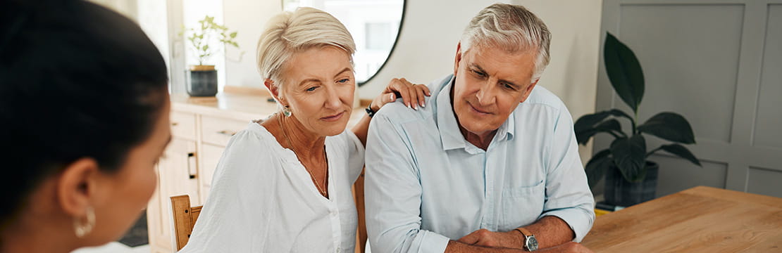 An elderly couple meeting with an advisor.